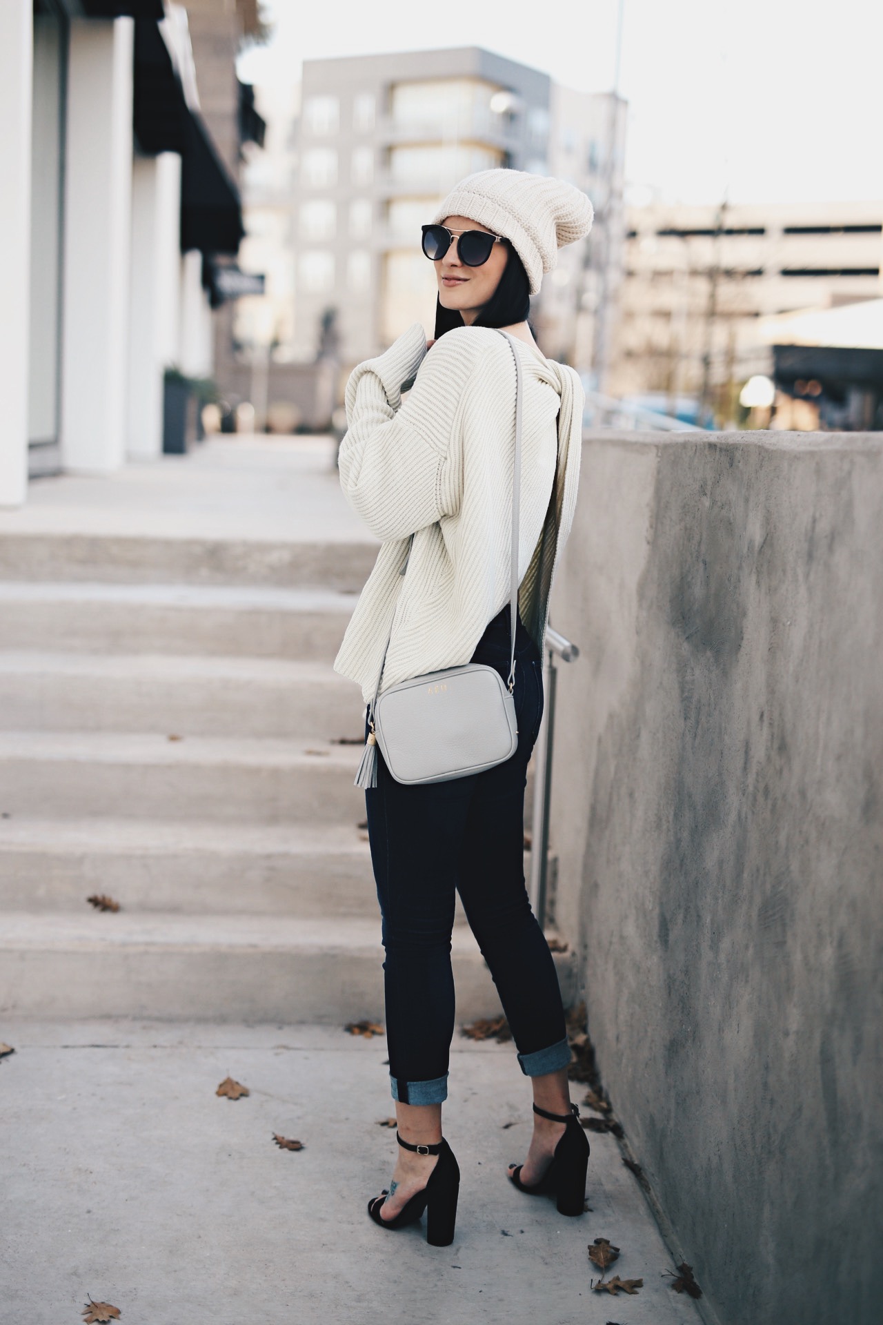 Ashley of DTKAustin is wearing a Chicwish Ivory open back sweater, a Gigi New York cross body bag, Steve Madden heels and Articles of Society Denim in Austin.
