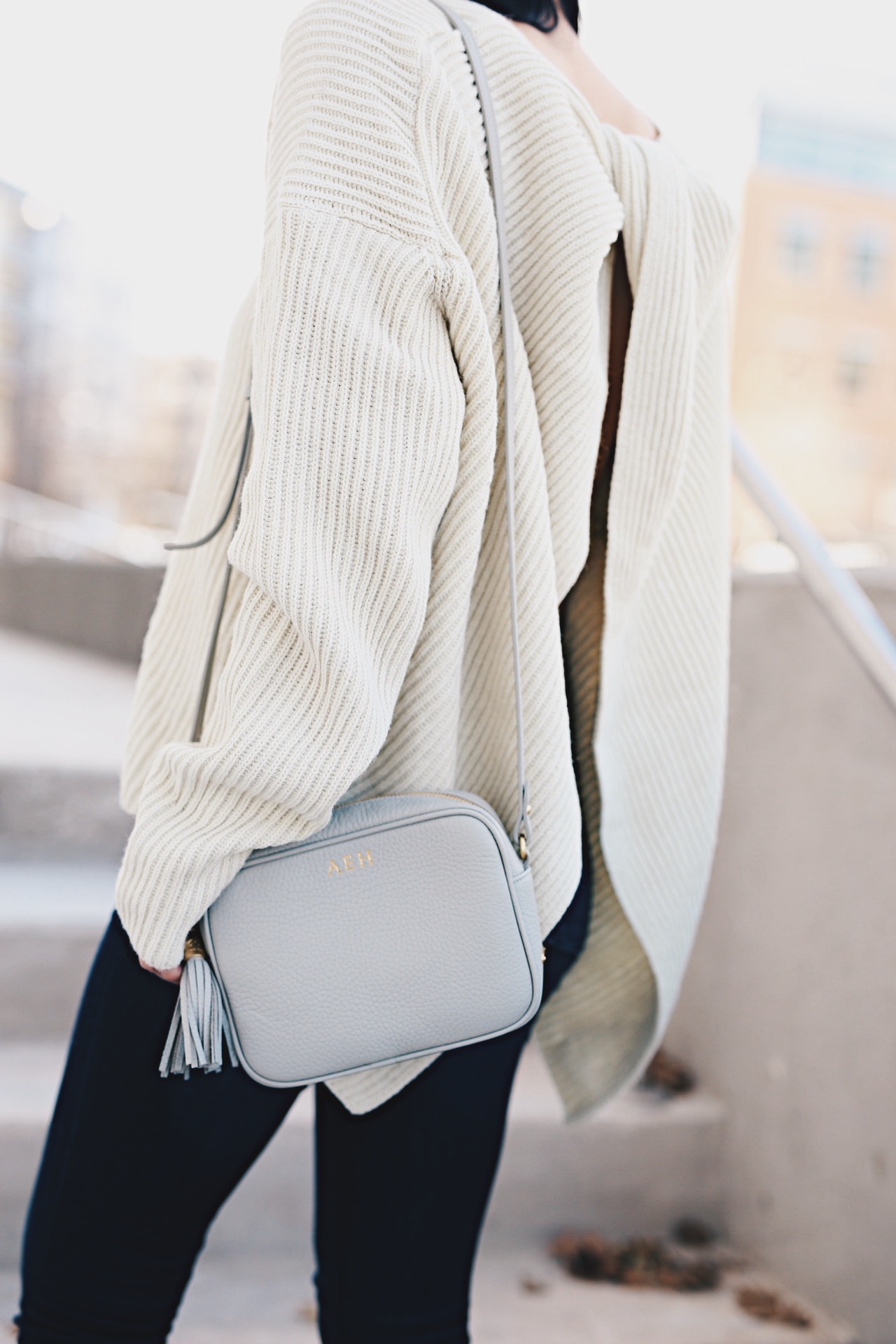Ashley of DTKAustin is wearing a Chicwish Ivory open back sweater, a Gigi New York cross body bag, Steve Madden heels and Articles of Society Denim in Austin.