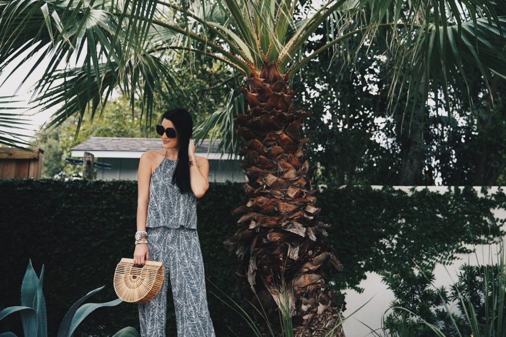 DTKAustin shares details on one of her go-to women's boutiques; Red Dress Boutique along with this beautiful palm print jumpsuit and bamboo bag.