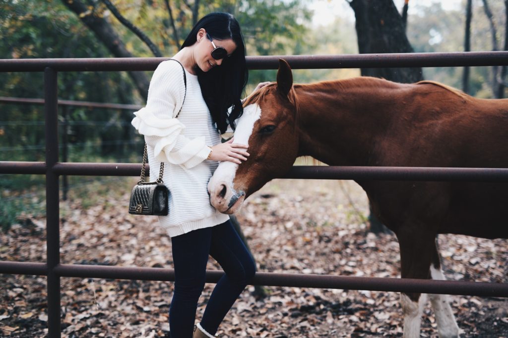 Austin Blogger DTKAustin shares staple ruffle sleeve sweater from Chicwish that is under $100 worn with Sorel snow boots in the Texas country.