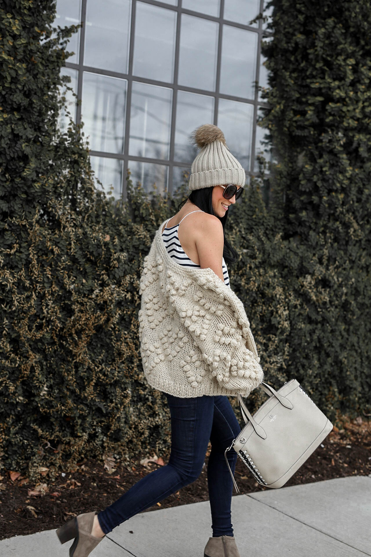 Wardrobe Staples featured by top US fashion blog Dressed to Kill; Image of a woman wearing Chicwish cardigan, CamiNYC cami, Mott & Bow jeans, Lucky booties, Henri Bendel handbag, T&J Designs beanie and Nordstrom sunglasses.