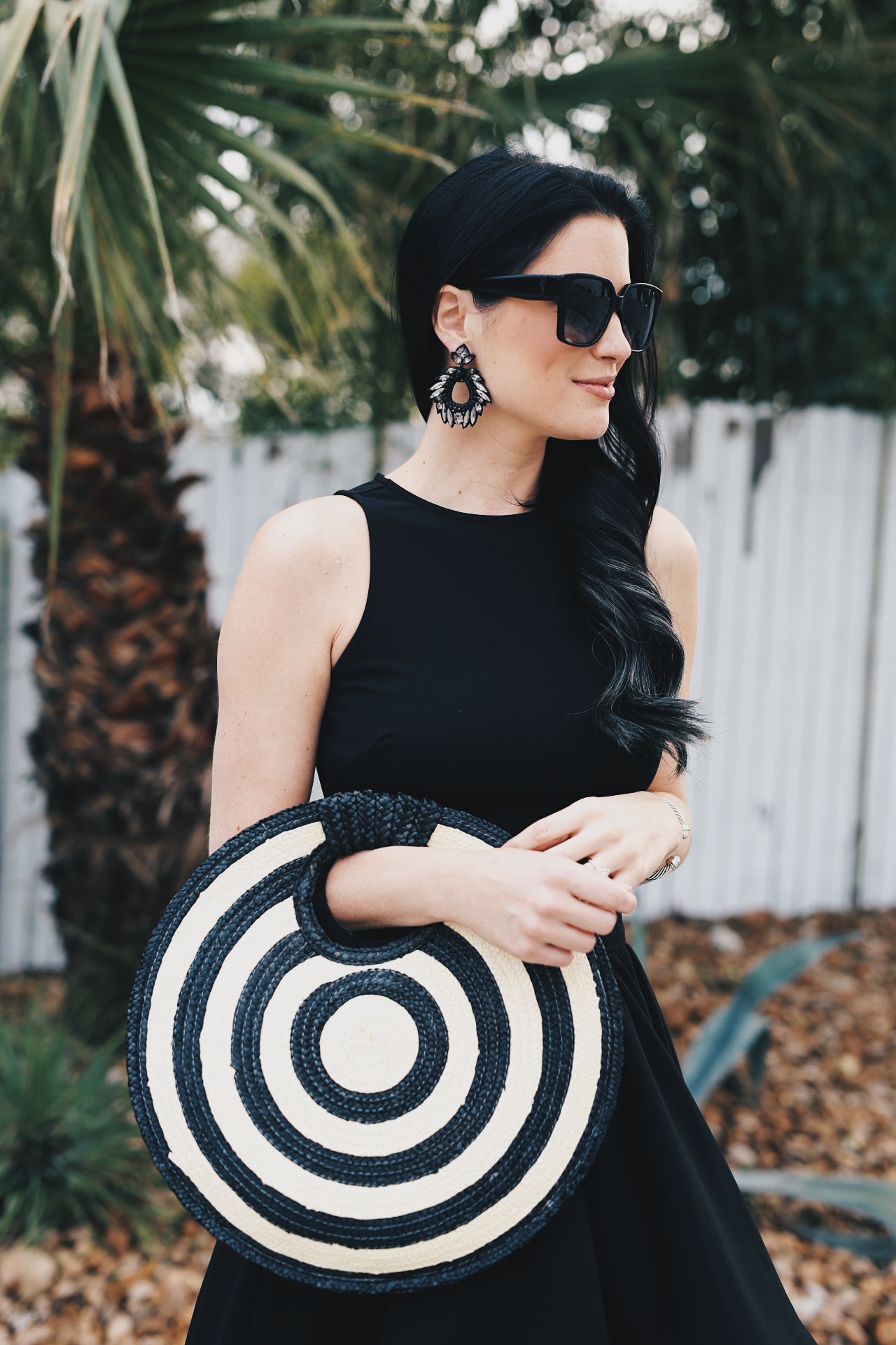 DTKAustin shares one of her most dramatic summer looks; a back two piece, high low skirt set from Akira with a straw round bag from Anthropologie.