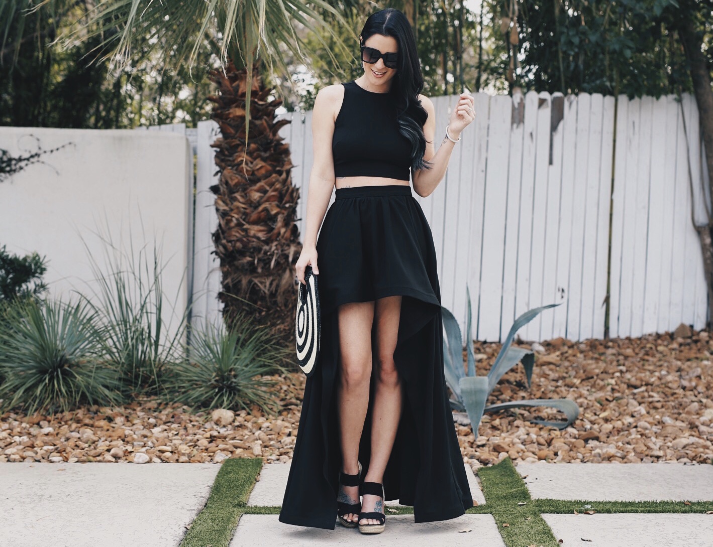 DTKAustin shares one of her most dramatic summer looks; a back two piece, high low skirt set from Akira with a straw round bag from Anthropologie.