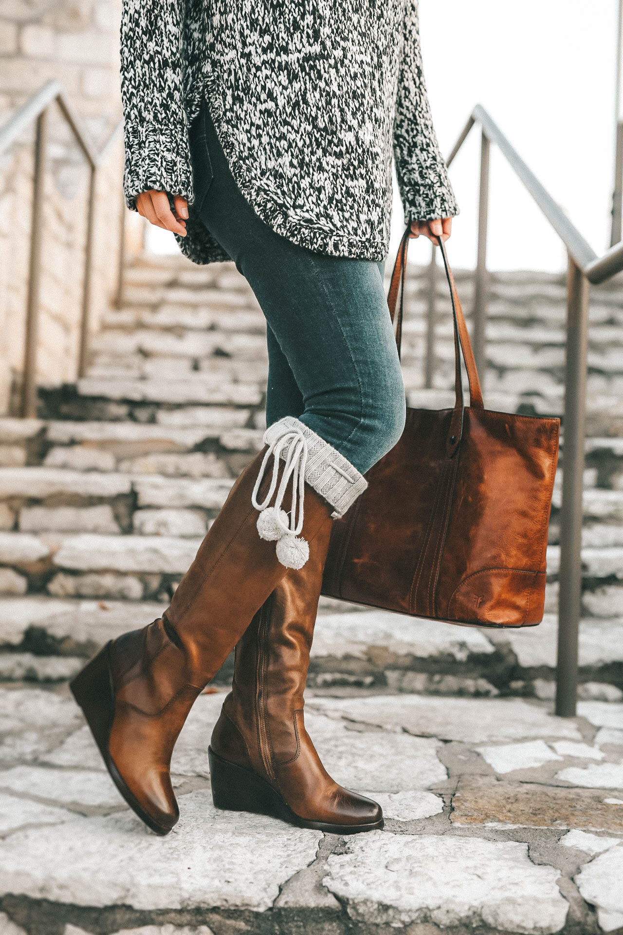 DTKAustin is sharing the best investment boots for Fall and Winter with Frye and Zappos. Ashley is wearing Knee high pom pom socks from UGG, skinny jeans from Levis, a chunky knit beanie from Sole Society, Melissa Frye Tote and a knit sweater from Nordstrom. || Dressed to Kill #winterboots #womensboots #fryeboots #dtkaustin
