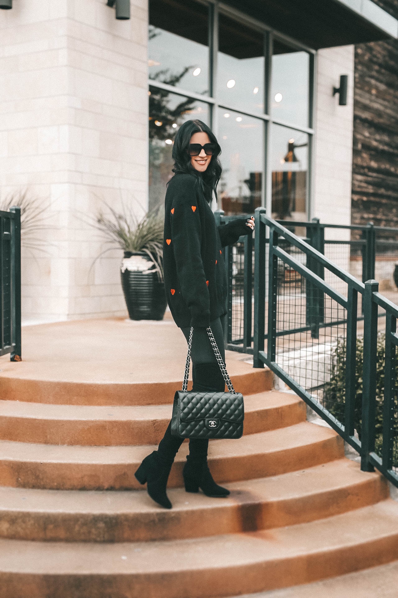 Cute Heart Sweaters by popular Austin fashion blog, Dressed to Kill: Image of a woman wearing a Chicwish sweater, Nordstrom leggings, Goodnight Macaroon boots, YSL sunglasses and Chanel bag.