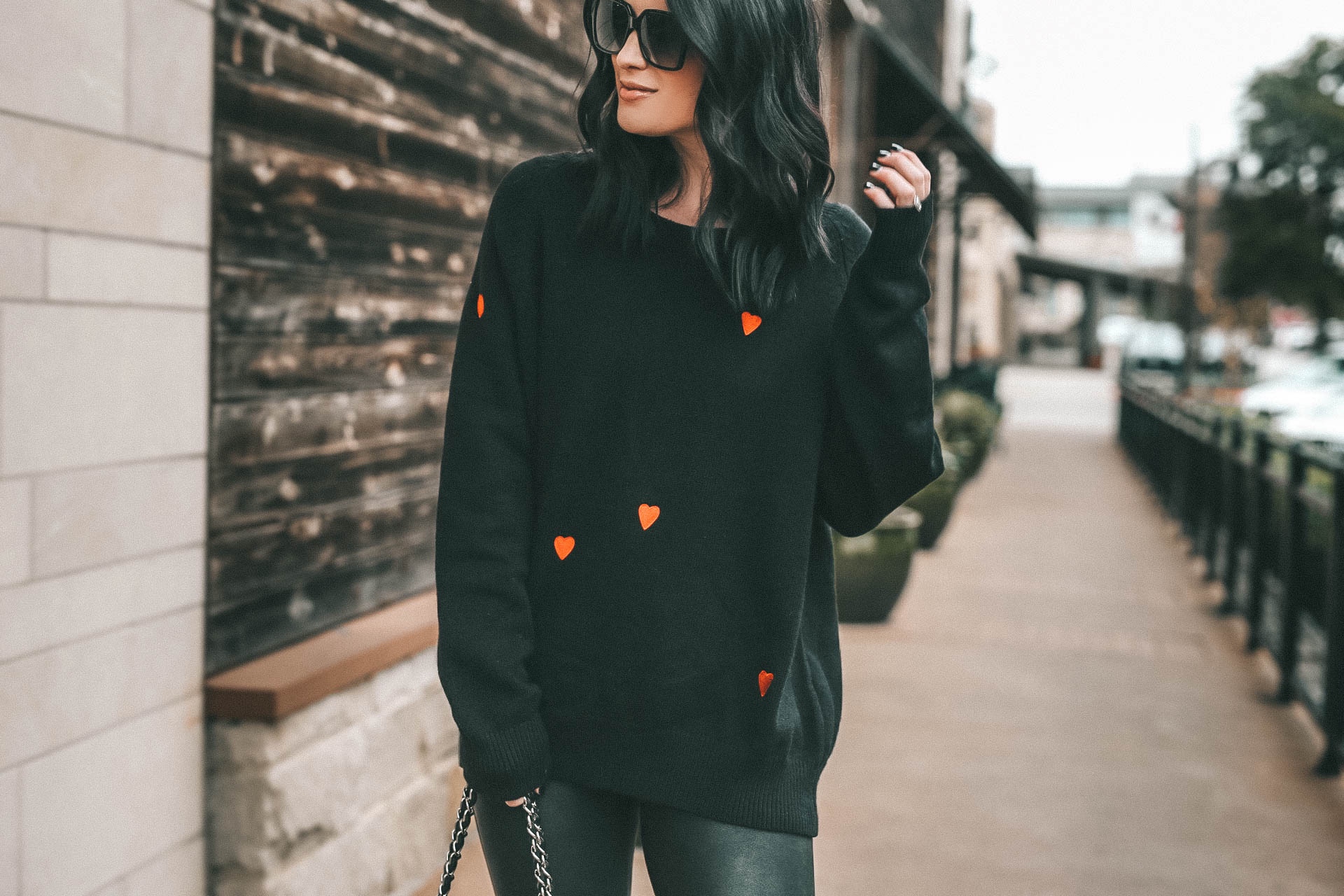 Cute Heart Sweaters by popular Austin fashion blog, Dressed to Kill: Image of a woman wearing a Chicwish sweater, Nordstrom leggings, Goodnight Macaroon boots, YSL sunglasses and Chanel bag.