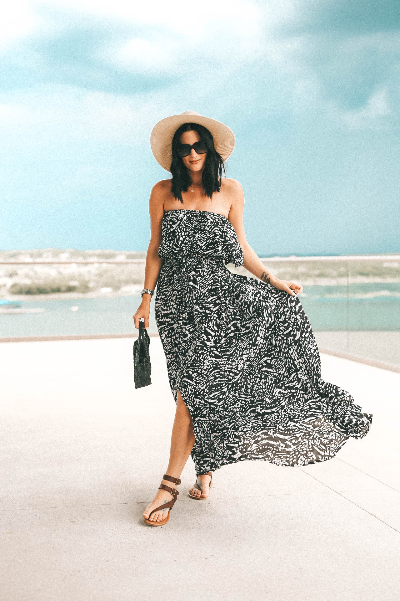 5 Affordable Summer Outfits from Walmart by popular Austin fashion blog, Dressed to Kill: image of a woman standing outside on a balcony wearing a Walmart Sofia Jeans By Sofia Vergara Strapless Maxi Dress Women's. 