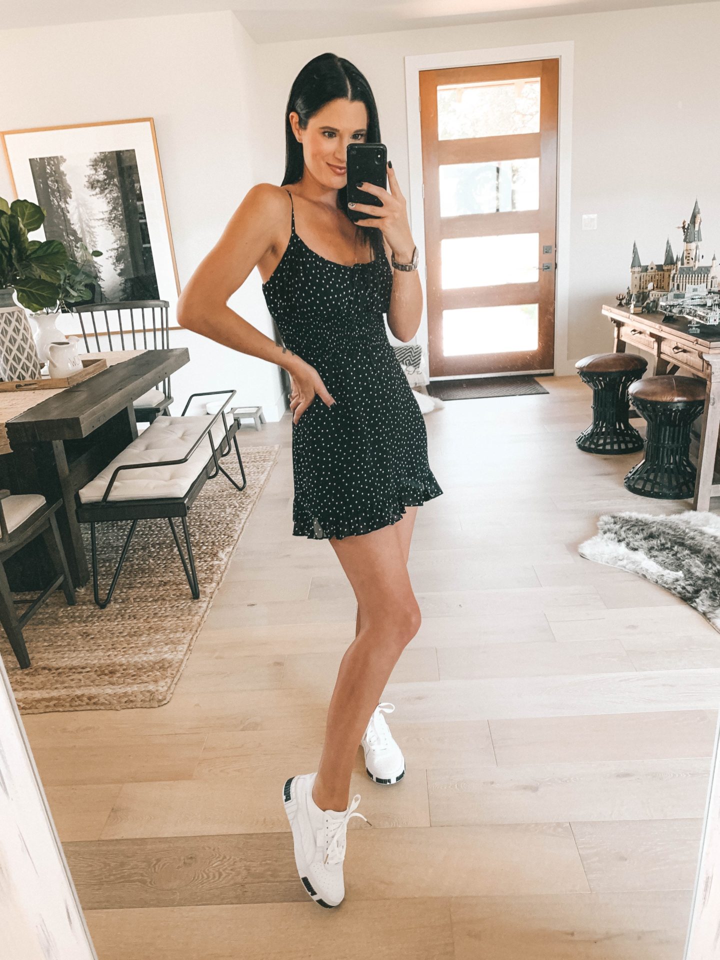 How to Wear White Sneakers by popular fashion blog, Dressed to Kill: image of a woman wearing a black and white polka dot dress and a pair of Puma sneakers.