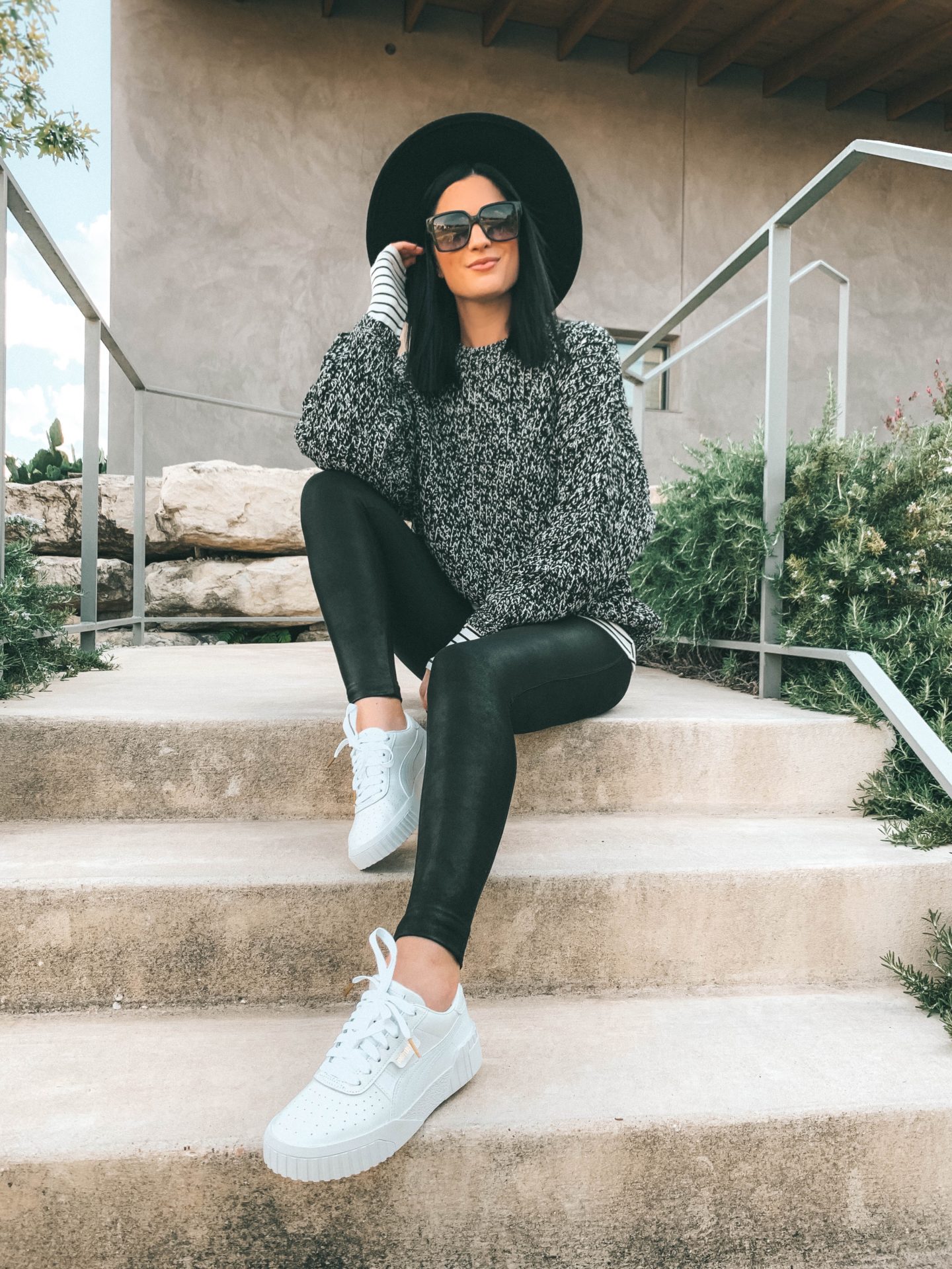 How to Wear White Sneakers by popular fashion blog, Dressed to Kill: image of a woman wearing a TopShop black and white sweater, black felt hat, black leggings, and white Puma sneakers.