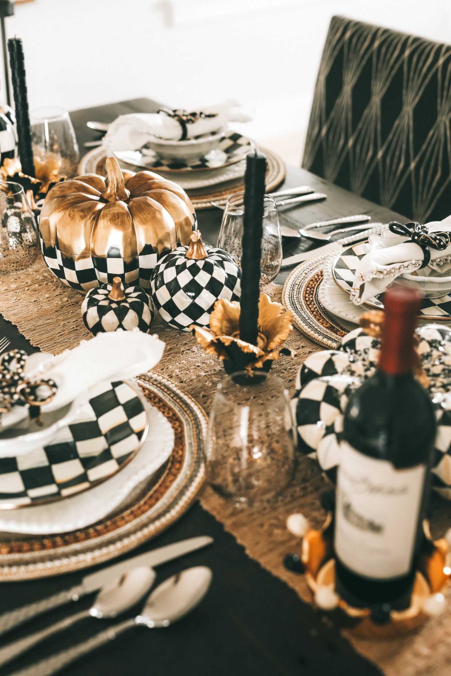 Decorating with MacKenzie Childs Fall Collection by popular Austin life and style blog Dressed to Kill: image of a table decorated with MacKenzie Childs Courtly Check and Harlequin pumpkins, Jeweled Circle Placemats, Sweetbriar chargers, Courtly Check dinner plates, Daffodil Candle Holders, raised check dinner candles, Sweetbriar small bowls, bow napkin rings, ivory napkins and check flatware. 