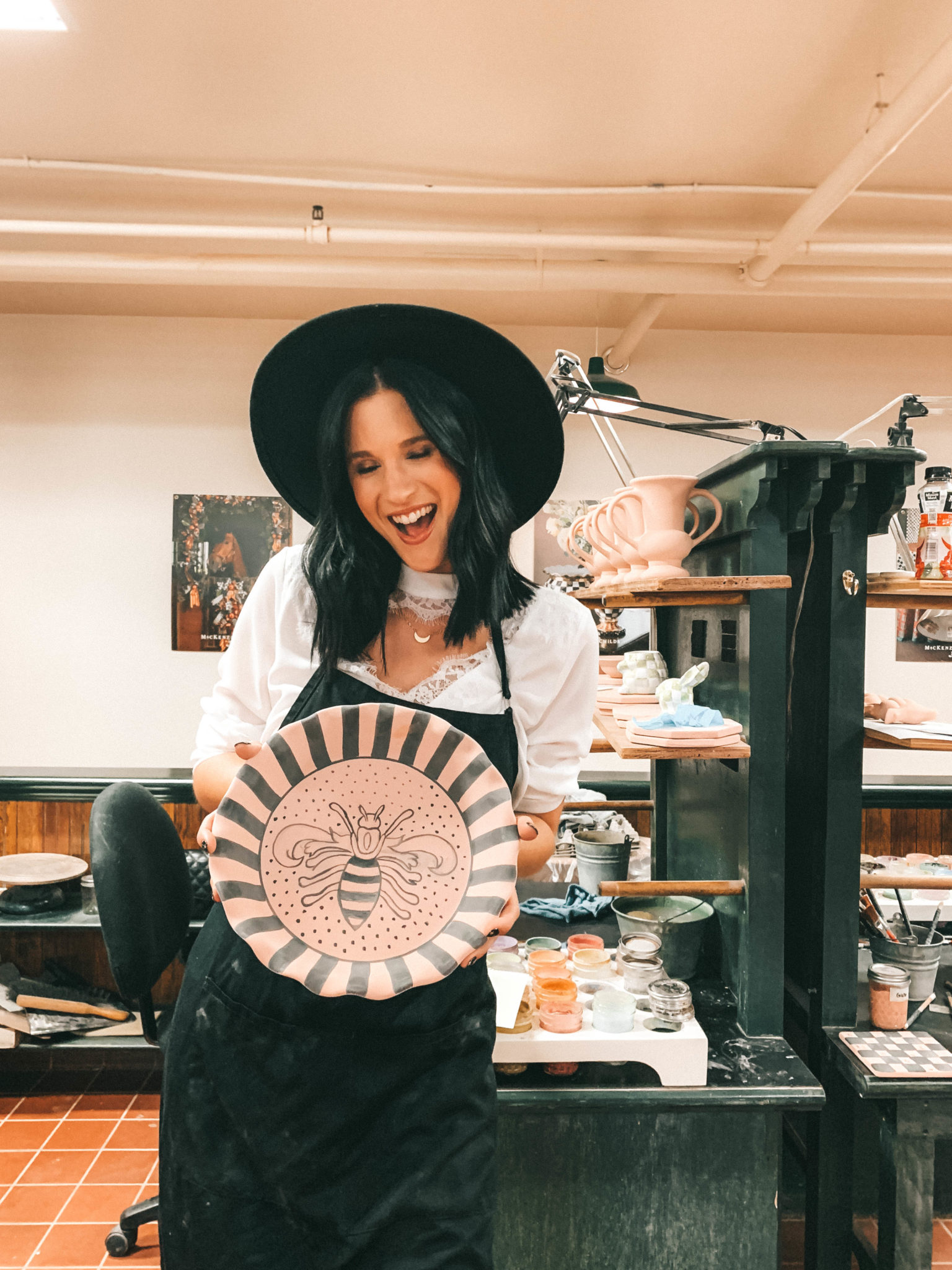 Decorating with MacKenzie Childs Fall Collection by popular Austin life and style blog Dressed to Kill: image of a woman holding a plate at the MacKenzie Childs headquarters.