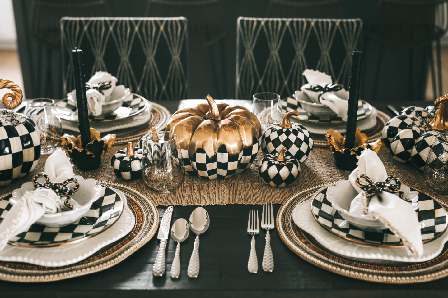 Decorating with MacKenzie Childs Fall Collection by popular Austin life and style blog Dressed to Kill: image of a table decorated with MacKenzie Childs Courtly Check and Harlequin pumpkins, Jeweled Circle Placemats, Sweetbriar chargers, Courtly Check dinner plates, Daffodil Candle Holders, raised check dinner candles, Sweetbriar small bowls, bow napkin rings, ivory napkins and check flatware. 