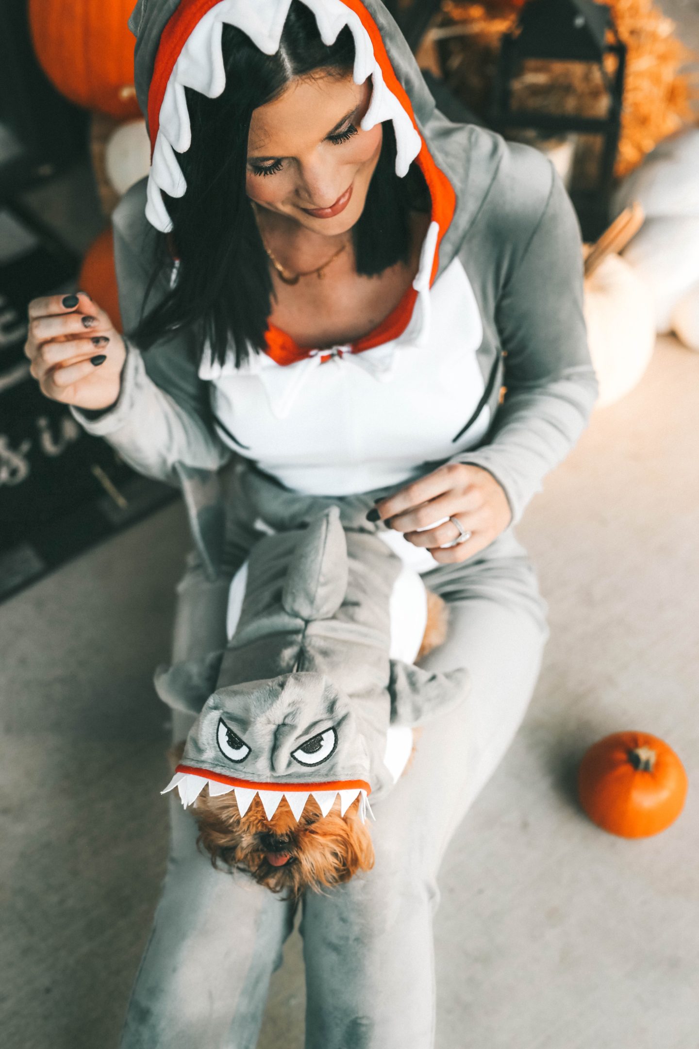My Favorite Matching Dog and Owner Halloween Costumes by popular Austin lifestyle blog, Dressed to Kill: image of woman outside wearing an Amazon Fun Costumes Womens Sassy Shark Costume and Nordstrom Converse Chuck Taylor® All Star® 70 Always On Low Top Sneaker and holding her dog who is wearing a Chewy Frisco Great White Shark Dog & Cat Costume.