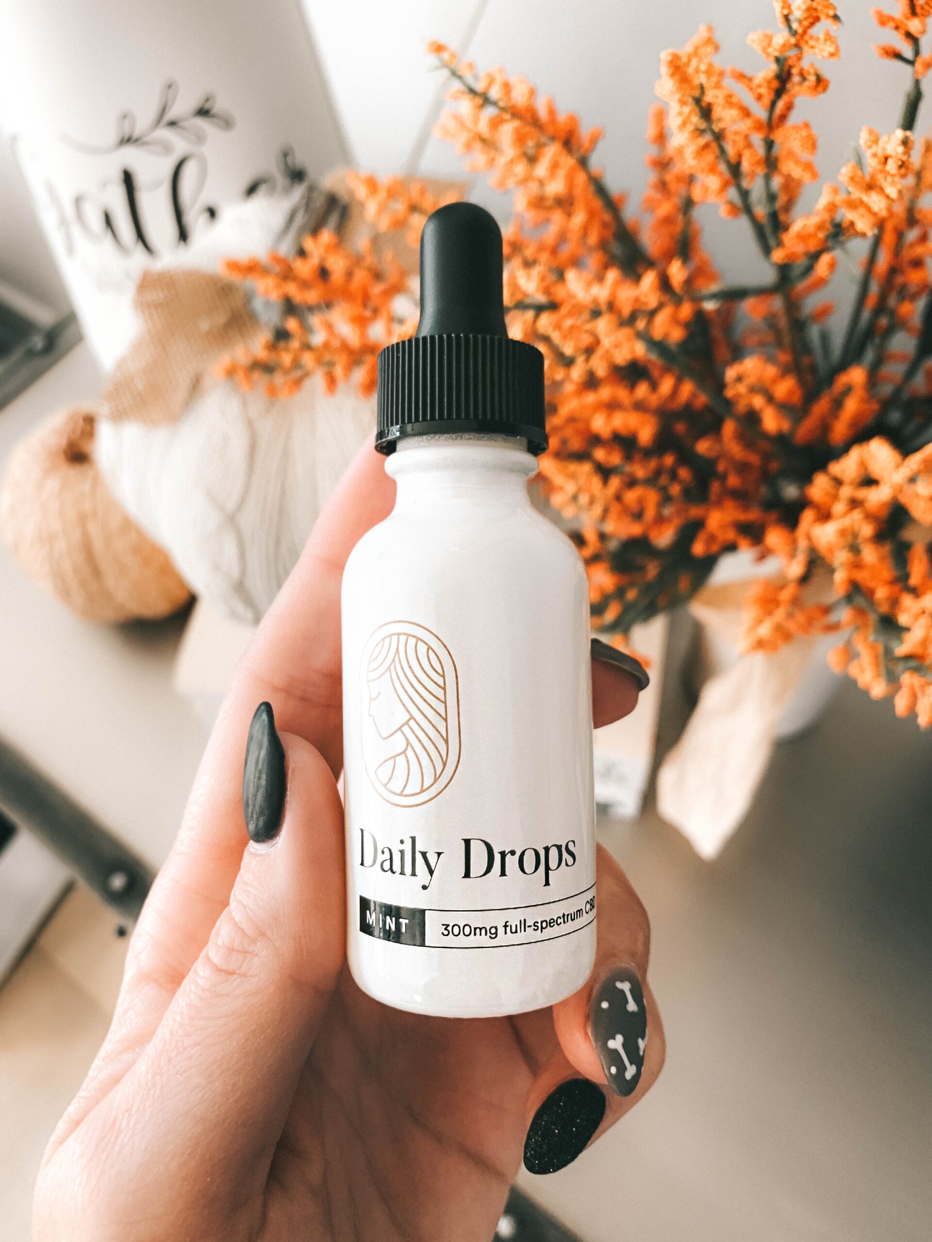 Equilibria CBD by popular Austin lifestyle blog, Dressed to Kill: image of a woman holding a bottle of Equilibria Daily Drops. 