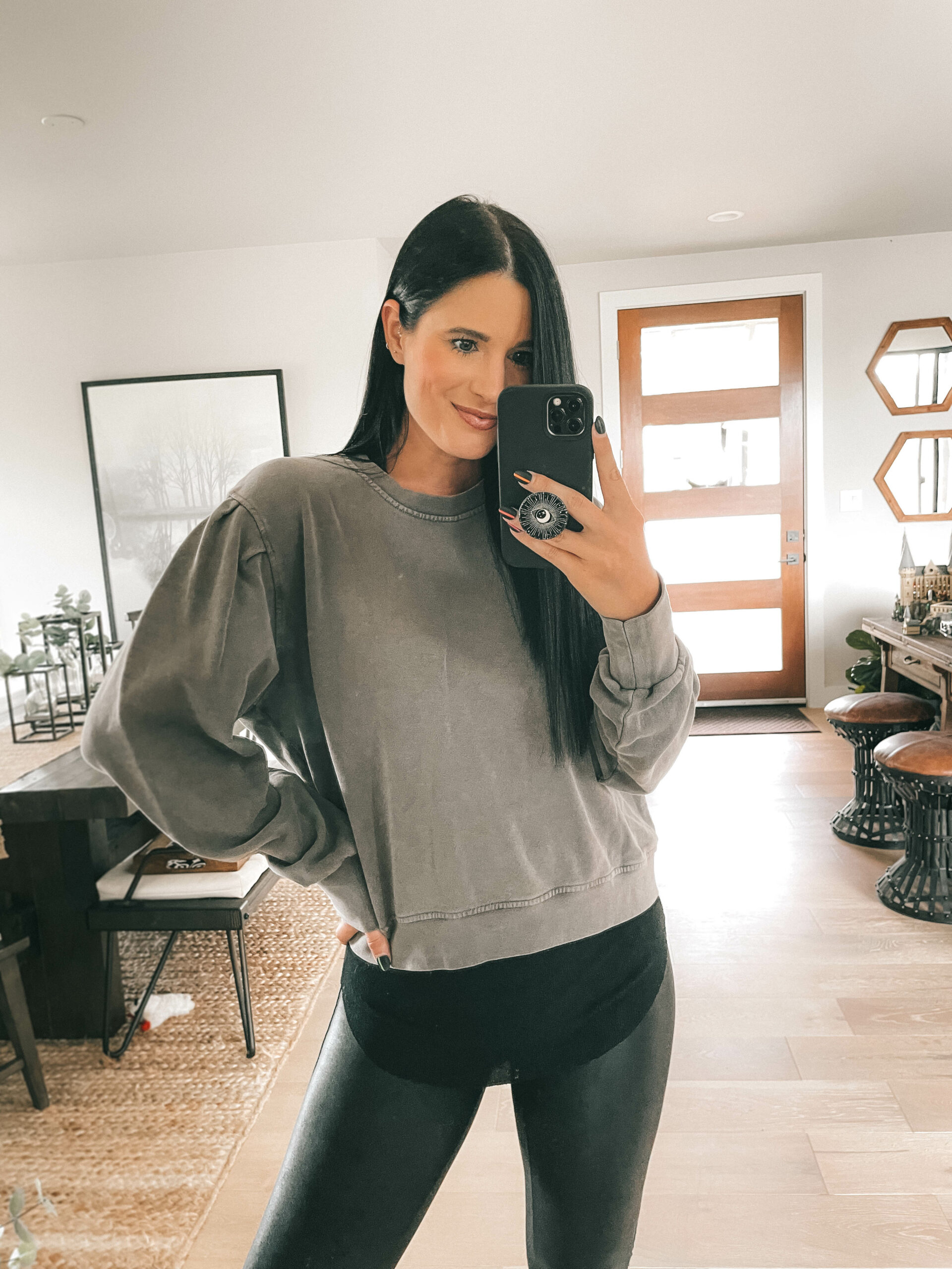 Nordstrom Anniversary Sale by popular Austin fashion blog, Dressed to Kill: image of a woman wearing a grey sweatshirt, black shirt, and black faux leather leggings. 